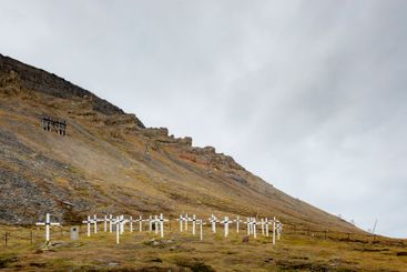 Grave markers by hill in Svalbard, Norway