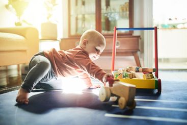 Childhood, game and a baby with toys for playtime,...