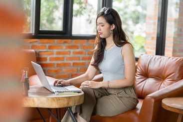 Portrait of Asian business female using laptop beautiful...
