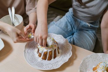 Mother and daughter decorating Easter cakes together.
