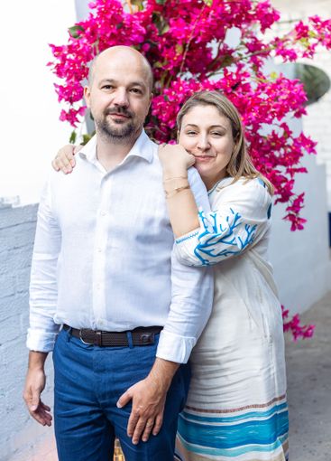A young married couple poses at an outdoor festive...