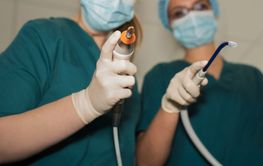 Hands of dentist surgeons with forceps and instruments...