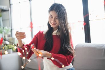 Asian Woman decorated house for Chinese New Year...