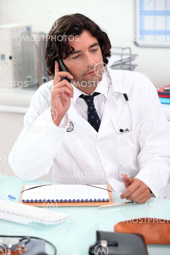 Doctor using a telephone at a desk