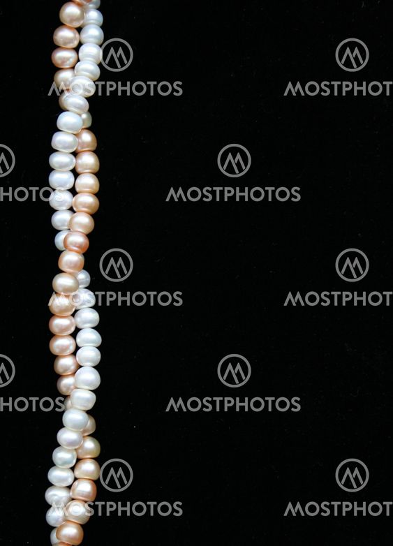 White and pink pearls on the black background
