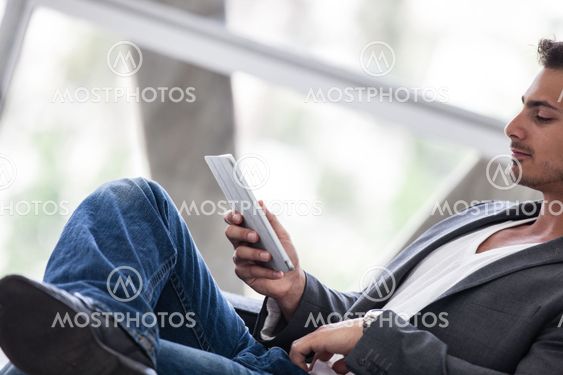 Good looking man in his 20s working on a mini think pad