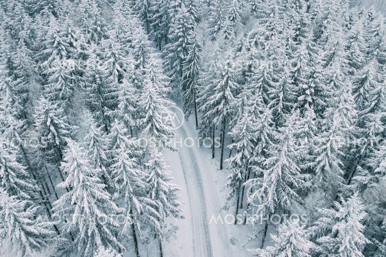 Aerial view of the mountain road in snowy winter