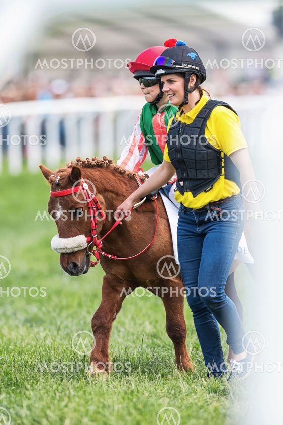 Pony racer warming up with her trainer and horse before...