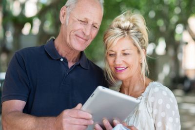 Mature couple reading information on a tablet