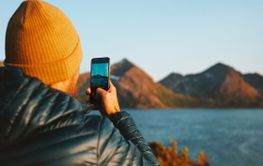 Man with smartphone taking photo in Norway travel lifestyle 