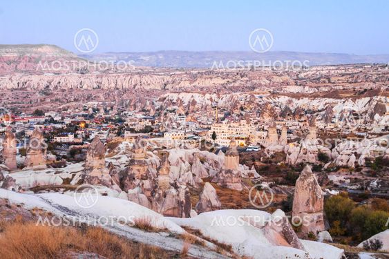 Rock cave and the village in late evening, cappadocia,...