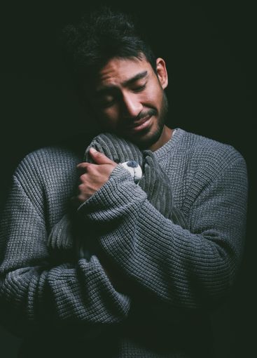 Studio, mental health and man with cuddle of teddy bear...