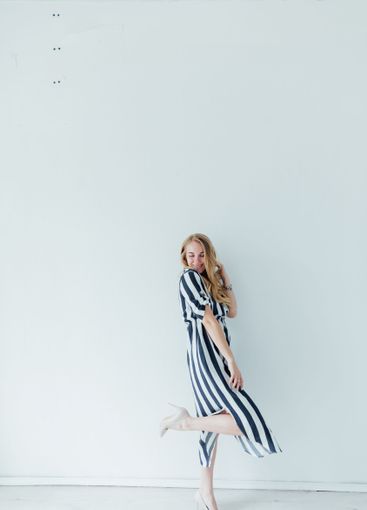 Beautiful fashionable woman in summer striped dress smiling