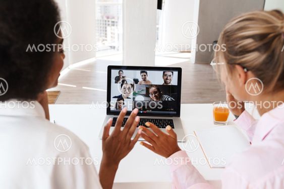 Multicultural girls waving hands while making conference...