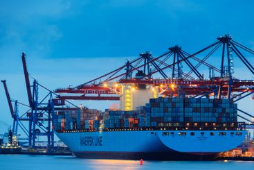 Cargo ship docked in Gothenburg harbour at dusk with...