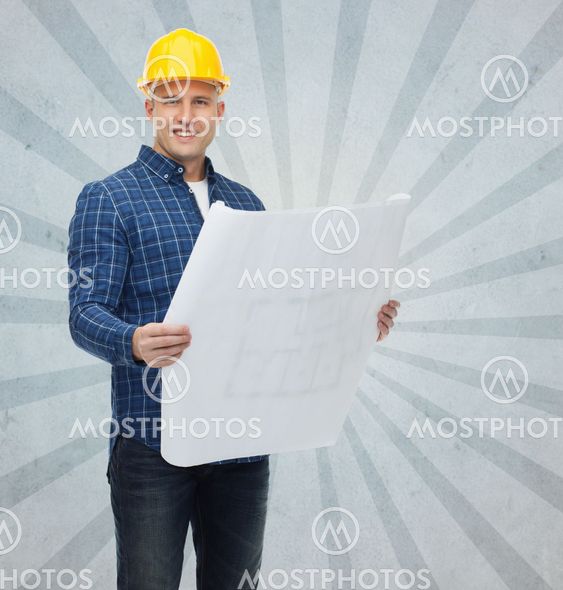 smiling male builder in helmet with blueprint