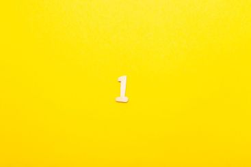 Top view of wooden number 1 one on yellow bright...