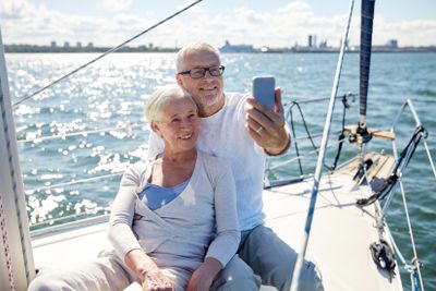 seniors with smartphone taking selfie on yacht