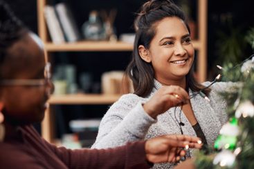 Women, decorate and Christmas tree for festive, holiday...