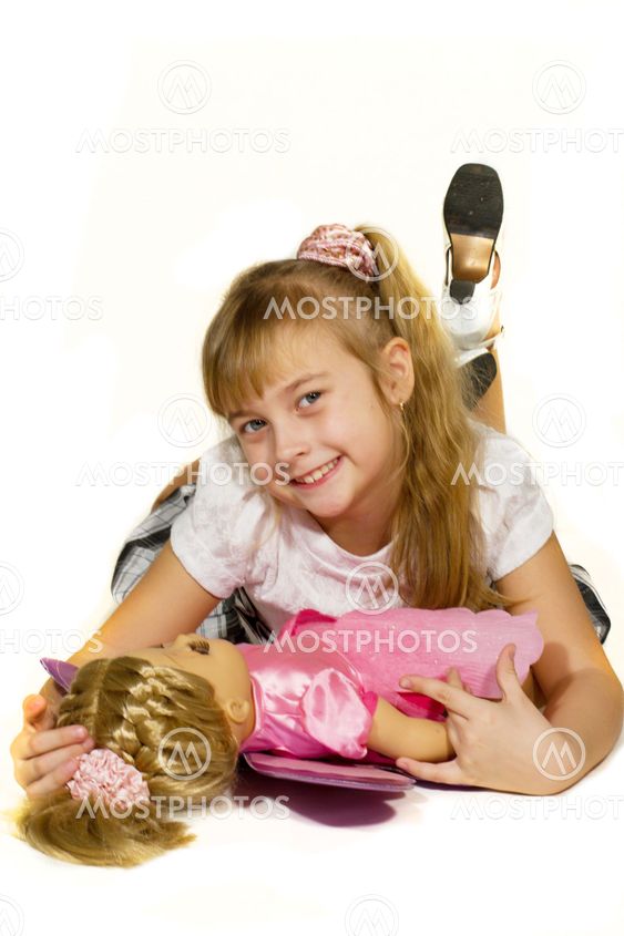 Beautiful little girl playing with a doll.