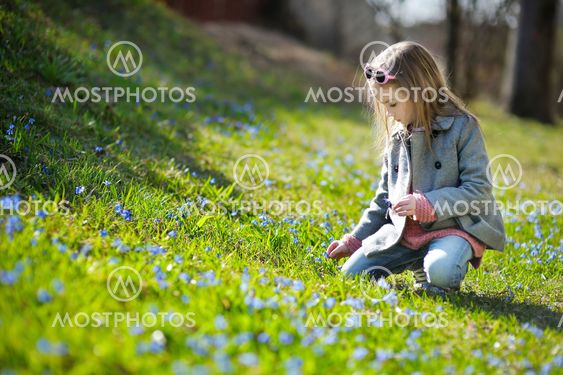 Adorable girl picking the first flowers of spring