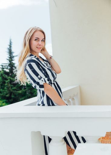 Beautiful fashionable woman in summer striped dress smiling