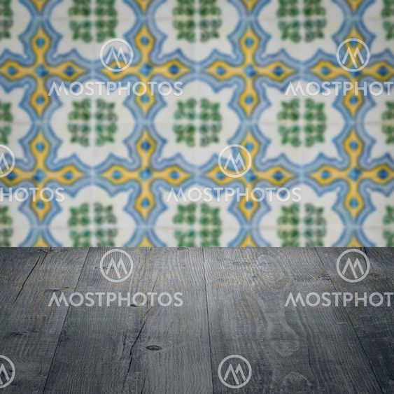 Wood table top and blur vintage ceramic tile pattern wall