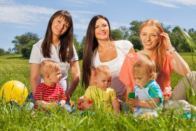 Three happy mothers with their babies sitting