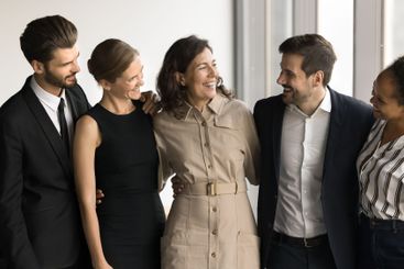 Five business colleagues hugging, stand together in office