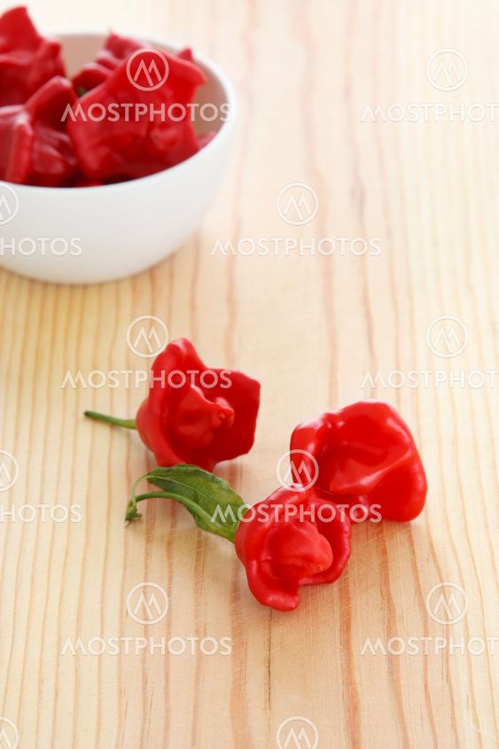 Hot chilli peppers over a wooden table.