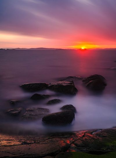 Tranquil Beach at Sunset: Dramatic Afterglow over Scenic...