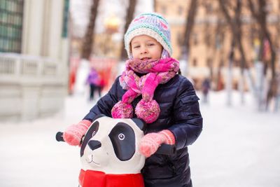 Adorable little happy girl skating on the ice-rink