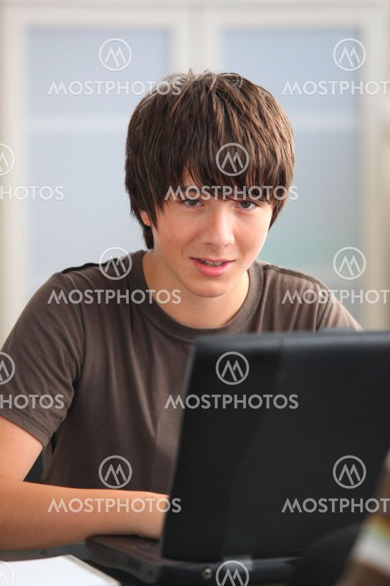 Teenage boy doing his homework on line