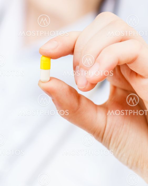 nurse holds pilule in finger