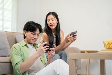 A happy Asian couple spends time together at home,...