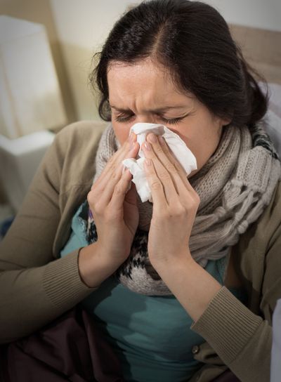 Portrait of sick woman blowing her nose