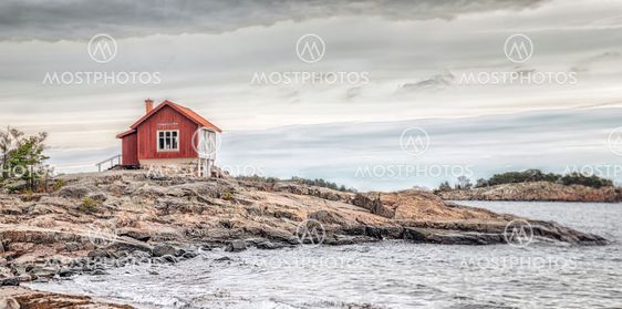 Red house at sea shore in dull colors at autumn