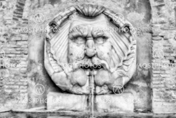 Defocused background of fountain with mask, Rome, Italy