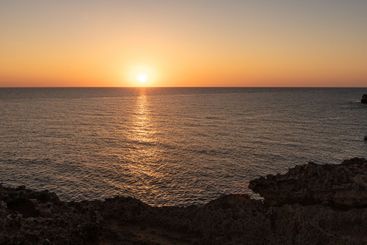 The serene sea at dawn or dusk, with calm, tranquil waters.