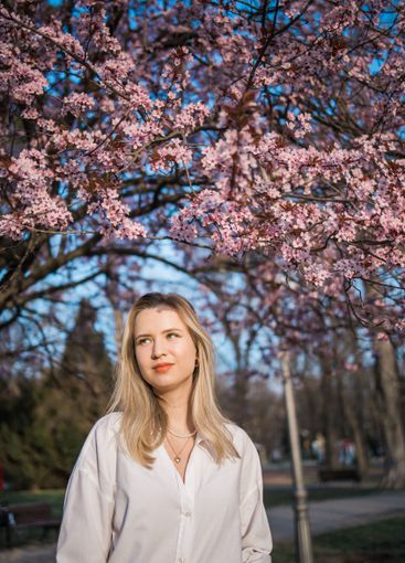 Woman with cherry flowers surrounded by blossoming trees...