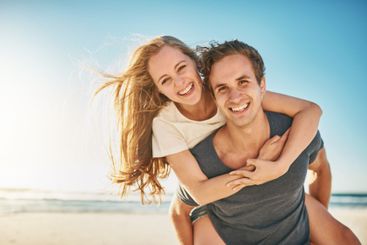 Portrait, piggy back and seaside with couple, love and...