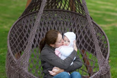 Mother and baby in a hanging chair in the park