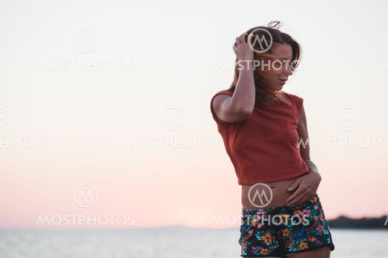 Young woman enjoying sunset by the sea