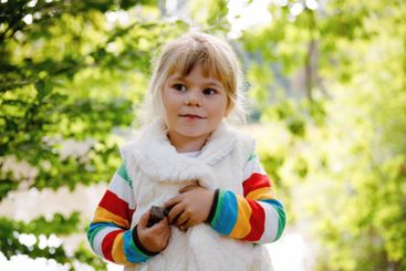 Cute little toddler girl making a walk through autumn...