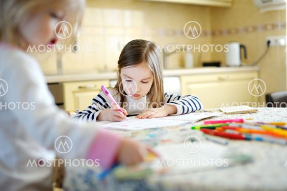 Two sisters drawing and learning together