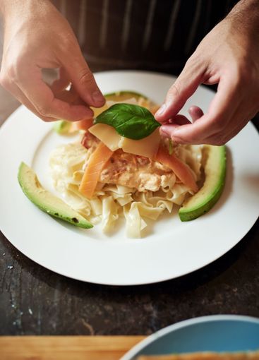Hands, chef or decorate food in plate with leaf at...