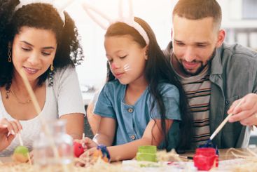 Happy family, painting eggs for easter in home,...