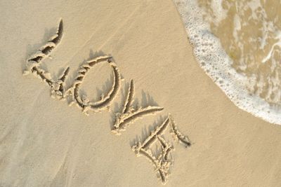 Inscription "love" on sand