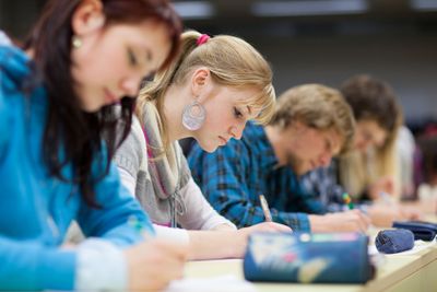 pretty, female college student sitting in a classroom...