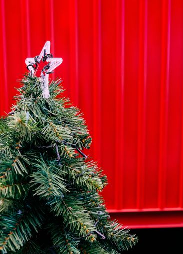 Decorated christmas tree on the background of a red wall